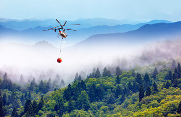 Fototapeta na wymiar Helicopter fighting forest fire - Intervention of firefighters