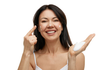 Fototapeta premium Portrait of skincare cleansing foamy product on female hand and woman applying it on face against white studio background. Concept of beauty and self care, wellness, skincare, hygiene procedures.