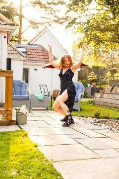 A Red Haired Young Woman Dancing And Having Fun Outside At A Summer Garden Party