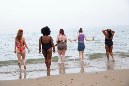 A mixed group of female friends having fun at the beach.