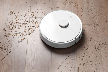 Smart robot vacuum cleaner removes scattered debris from the laminate floor.