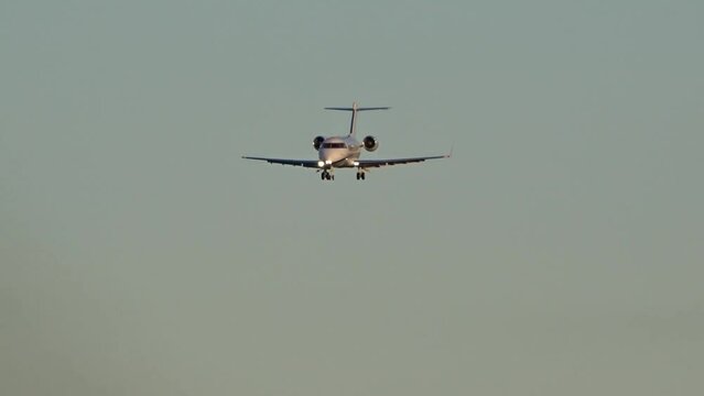 Mid size corporate jet final approach into airport airfield evening dusk