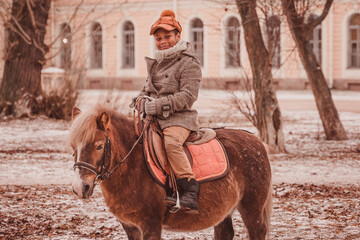 Naklejka premium Перейти к странице|123456Далее little rider smiling while riding a pony