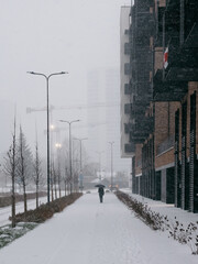 Snow in Vilnius. A lonely man under an umbrella walks down the street in a snowstorm