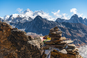 Сairn, pile of stones and snow capped Everest, Nuptse and Lhotse mountains of the Himalayas during EBC Everest Base Camp or Three Passes trekking. View from Gokyo Ri, Nepal. - obrazy, fototapety, plakaty