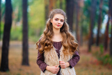 Portrait of beautiful blonde curl girl in medieval dress and fur vest on  nature. Young worker in rural scene.Warm colorful art work.
