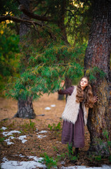 Portrait of beautiful blonde curl girl in medieval dress and fur vest on  nature. Young worker in...