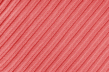 Jersey textile background , red diagonal striped knitted fabric. Woolen knitwear, sweater, pullover surface texture, textile structure, cloth surface, weaving of knitwear material