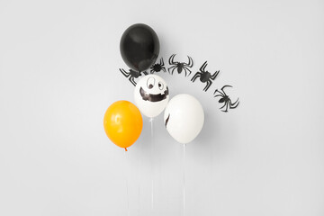 Halloween balloons with paper spiders on white background