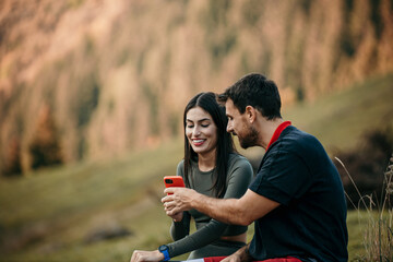 Diverse man and woman in fitness gear enjoying a water break while staying connected with their...
