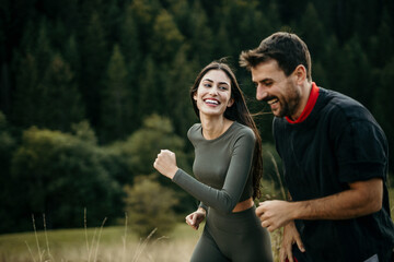 A diverse pair happily running side by side on a hillside trail