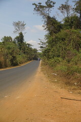 Mountain landscape in a valley where the road is red dirt.
