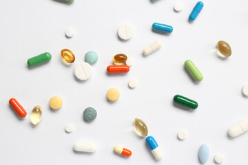 Fish oil capsules and different pills on white background