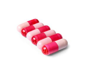 Pink pills on white background