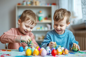 Obraz premium Two happy boys painting Easter eggs together.