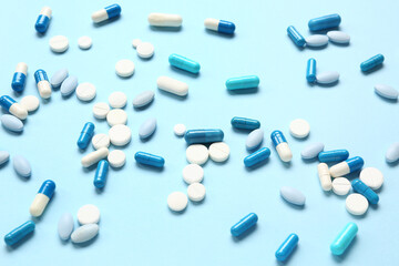 Many different pills on blue background