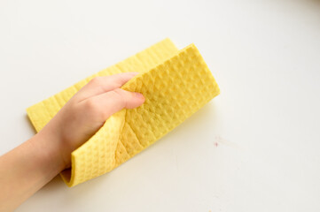 A child wipes a dirty surface with a special napkin