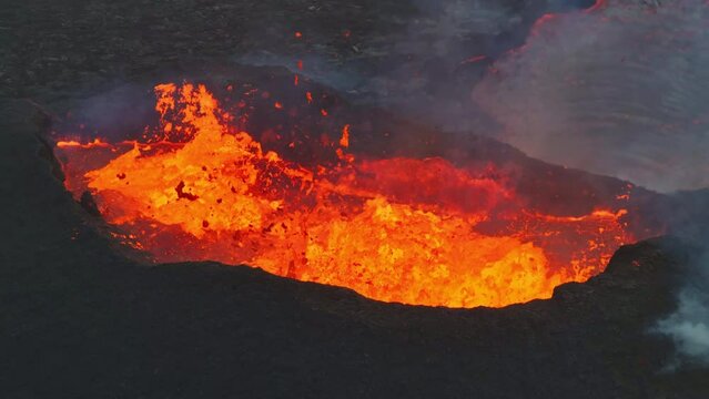 Aerial drone fly view over active volcanic crater eruption. Hot lava and magma coming out of the crater. Tourist attraction in Iceland Litli-Hr&uacute;tur eruption 2023. Beautiful and dangerous disaster.