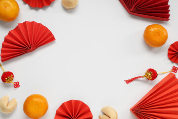 Frame made of fortune cookies with mandarins and Chinese symbols on white background. New Year...