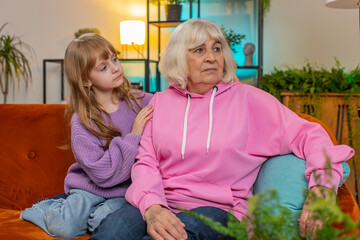 Loving worried kind girl granddaughter consoling sad crying grandmother helping with problem...