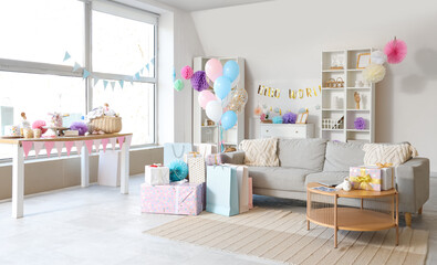 Interior of living room decorated for baby shower party with sofa, balloons and gifts
