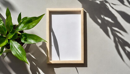 enhancing the mockup overlay in a horizontal, two vertical sheets of textured white paper against a soft gray table background. the natural light creates subtle shadows from an with leaves on table