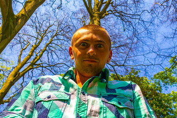 Man makes joking faces in the park in Lisse Netherlands.