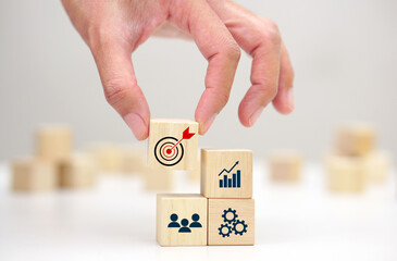 Hand holding a wooden block cube with target icon symbol. Business strategy and target of business.