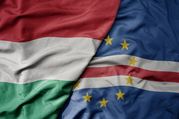 big waving national colorful flag of cape verde and national flag of hungary .