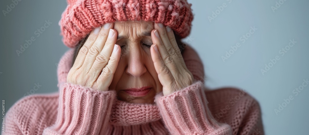 Canvas Prints Beautiful woman in pink sweater and hat covering her eyes with a stylish and mysterious look