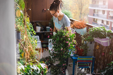 Woman taking care of her plants on the balcony
