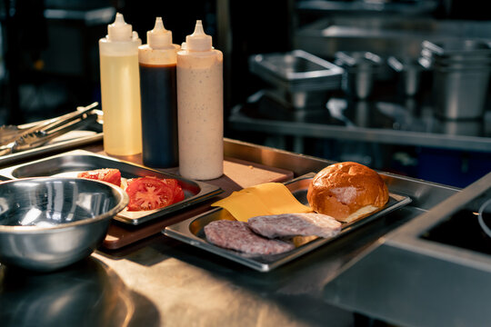 In the restaurant's kitchen there are gravy boats and all the ingredients for assembling burger