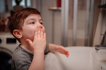 Little Boy Washing Face at Sink in Daily Hygiene Routine