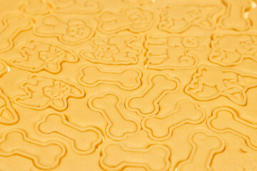 Obraz premium The pattern on the raw dough. Carved cookie shapes in the shape of bones and dogs