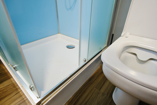 The shower cabin is located next to the toilet bowl in the bathroom interior.