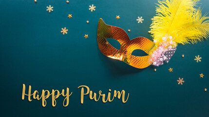 Happy Purim carnival decoration concept made from golden mask star and glitter on dark background....