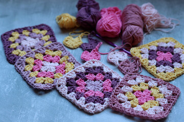 Handmade crocheted zigzag ornaments on grey background with copy space. Colorful cotton granny...