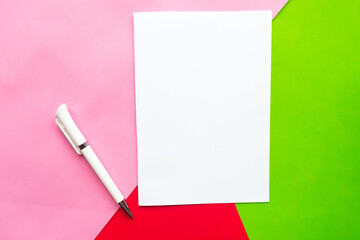 White mockup blank and pen on geometric green, pink and red background. Minimal concept, copy space...