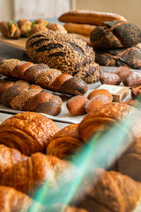 Assortments of bread, freshly baked on the shelf. Bakery goods. Variety of loaves and buns. 
