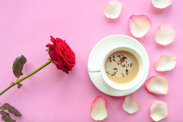 Flat lay photo with coffee cup and red rose on pink background. Valentine's Day or Wedding greeting...