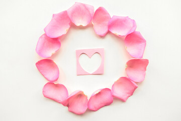 Love composition - figure of heart in the center of a pink petals frame