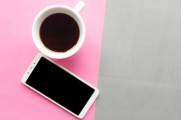 Coffee cup and mockup mobile on gray and pink pastel background. Top view. Minimal concept