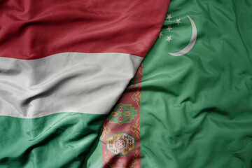 big waving national colorful flag of turkmenistan and national flag of hungary .