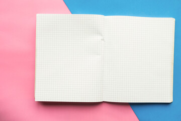 Open notebook on blue and pink background. Flat lay, copy space