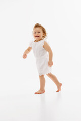 Firs step. Full length portrait of little girl in cute dress have fun and running against white studio background. Concept of childhood, motherhood, life, carefree, birth. Copy space for ad