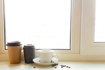 Coffee cup and take away coffee on the windowsill