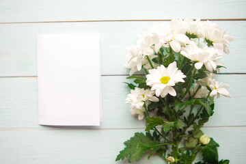 bouquet of white chrysanthemums and white mockup blank, top view