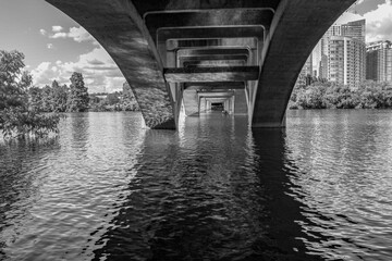 Black and white photo from the under the bridge of Lady Bird Lake with views of N. Lamar Blvd and...