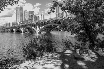 Black and white photo from the shore of Lady Bird Lake with views of N. Lamar Blvd and the cityscape of Austin Texas.