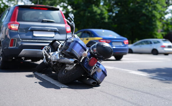 Blue motorcycle lying on road near car closeup. Road traffic accidents with motorcyclists concept